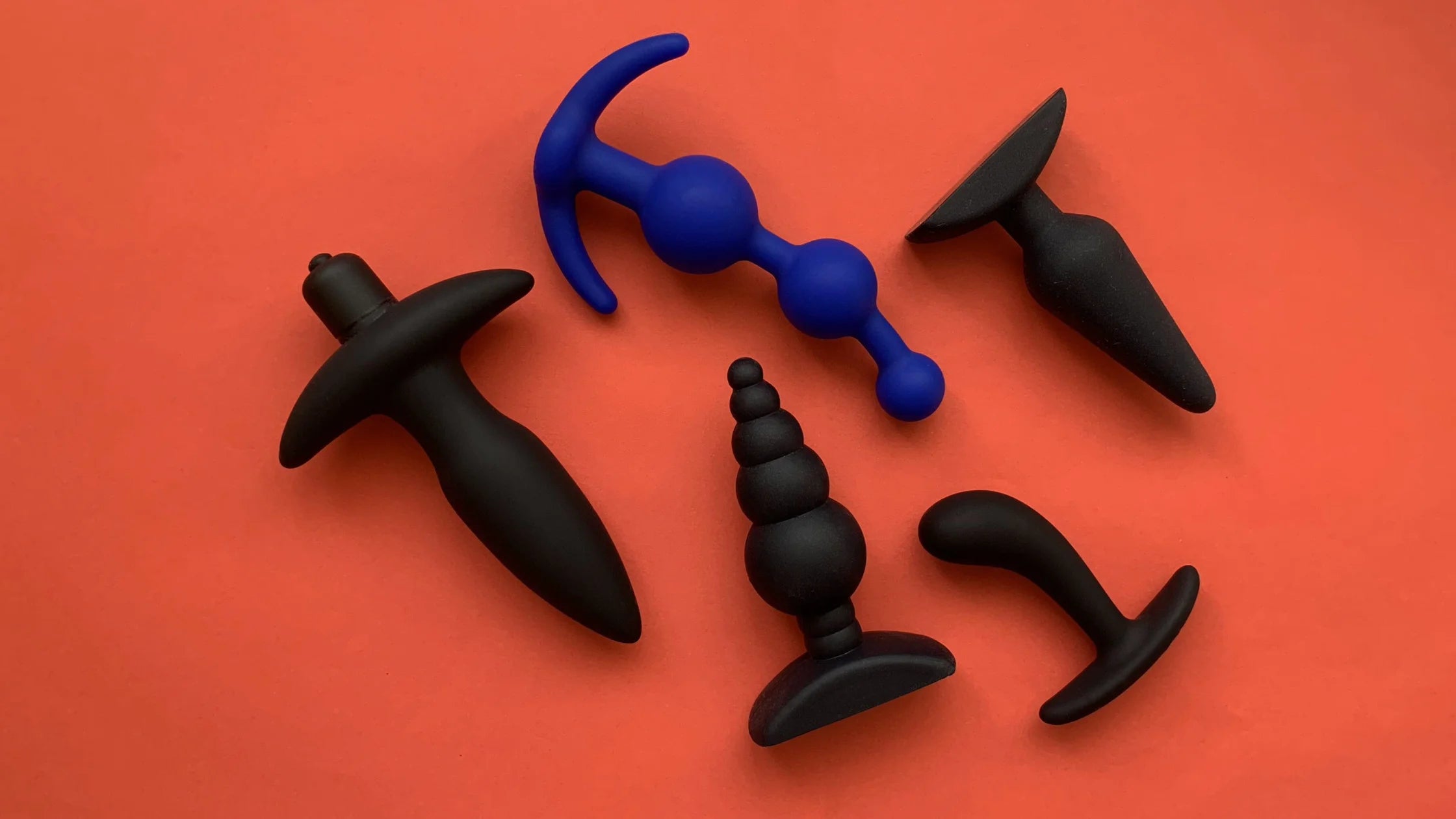 different style of butt plugs 4 black 1  blue with orange background sex toy numen wellness
