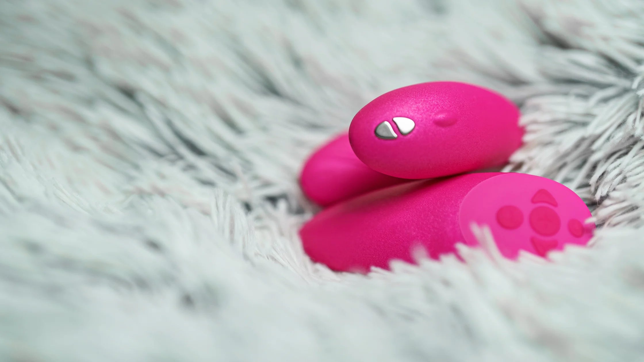 pink remote controlled vibrator on soft white blanket sex toy numen wellness