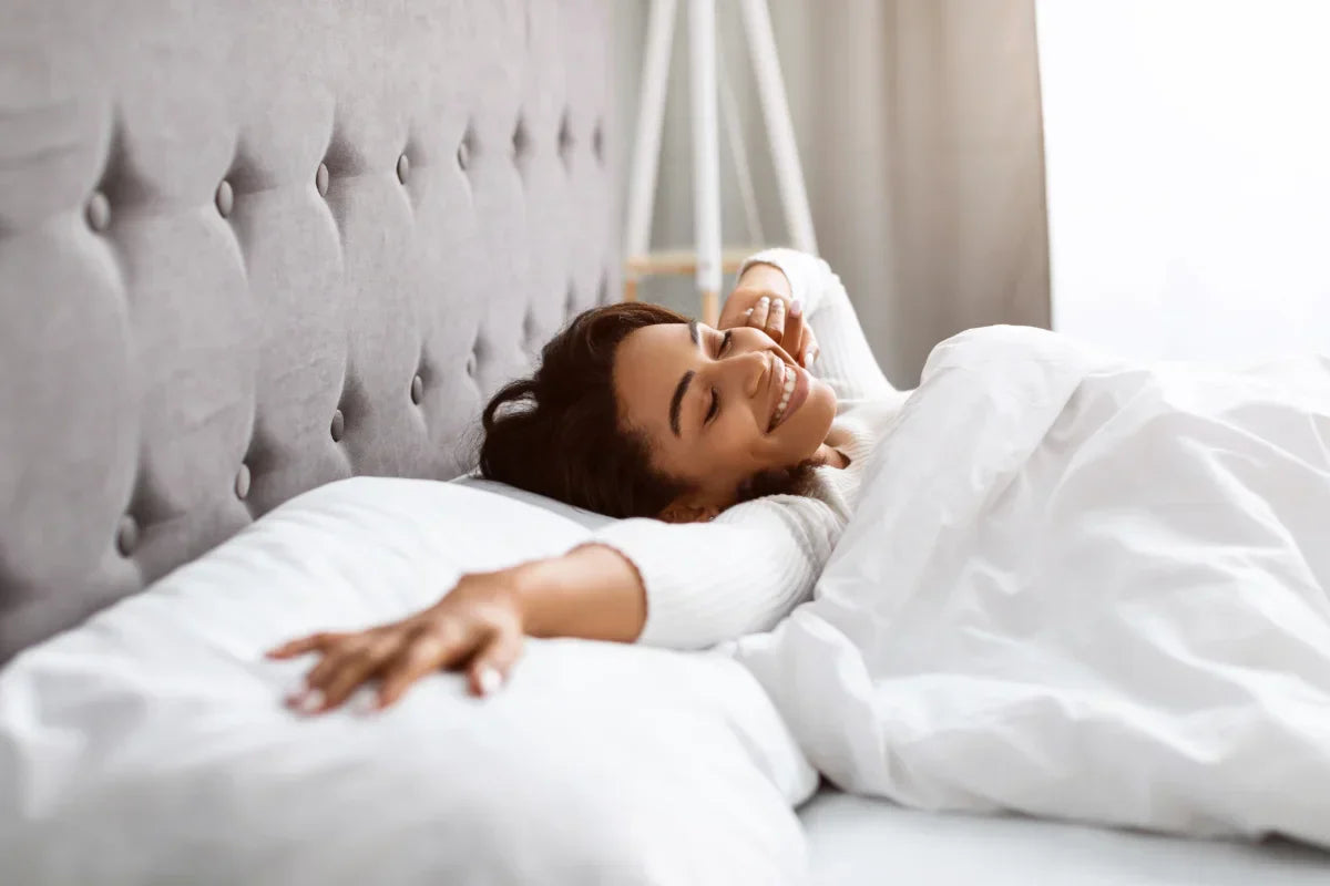 women smiling in bed with shite sheets numen wellness