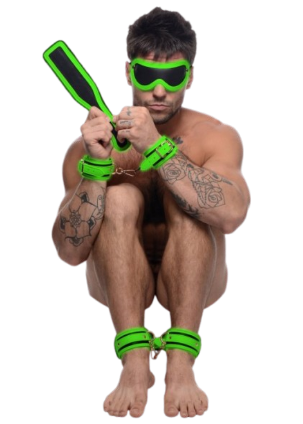 Man wearing glowing cuffs and blindfold, holding paddle