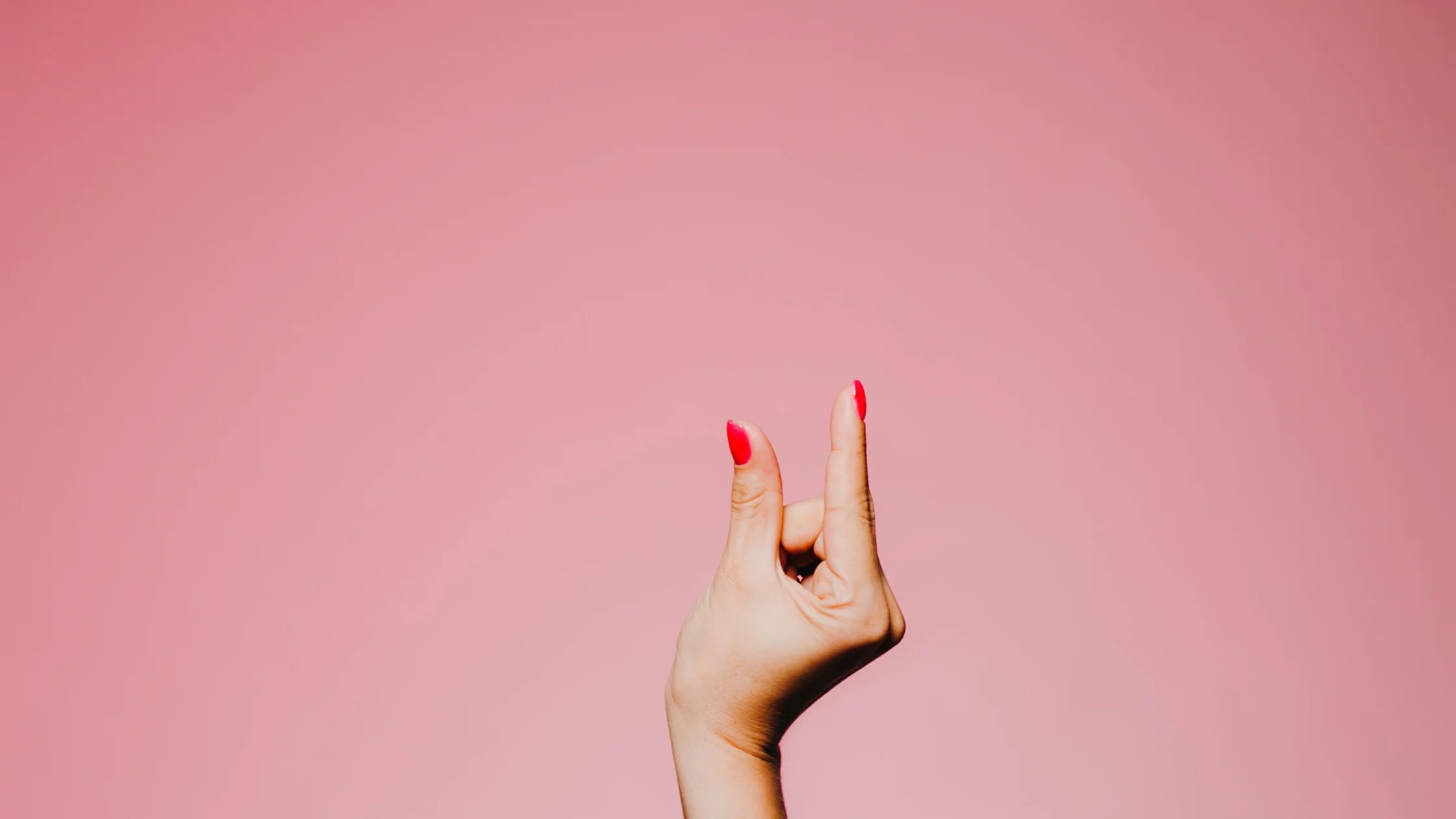 hand pinch small size pink background sex toys numen wellness