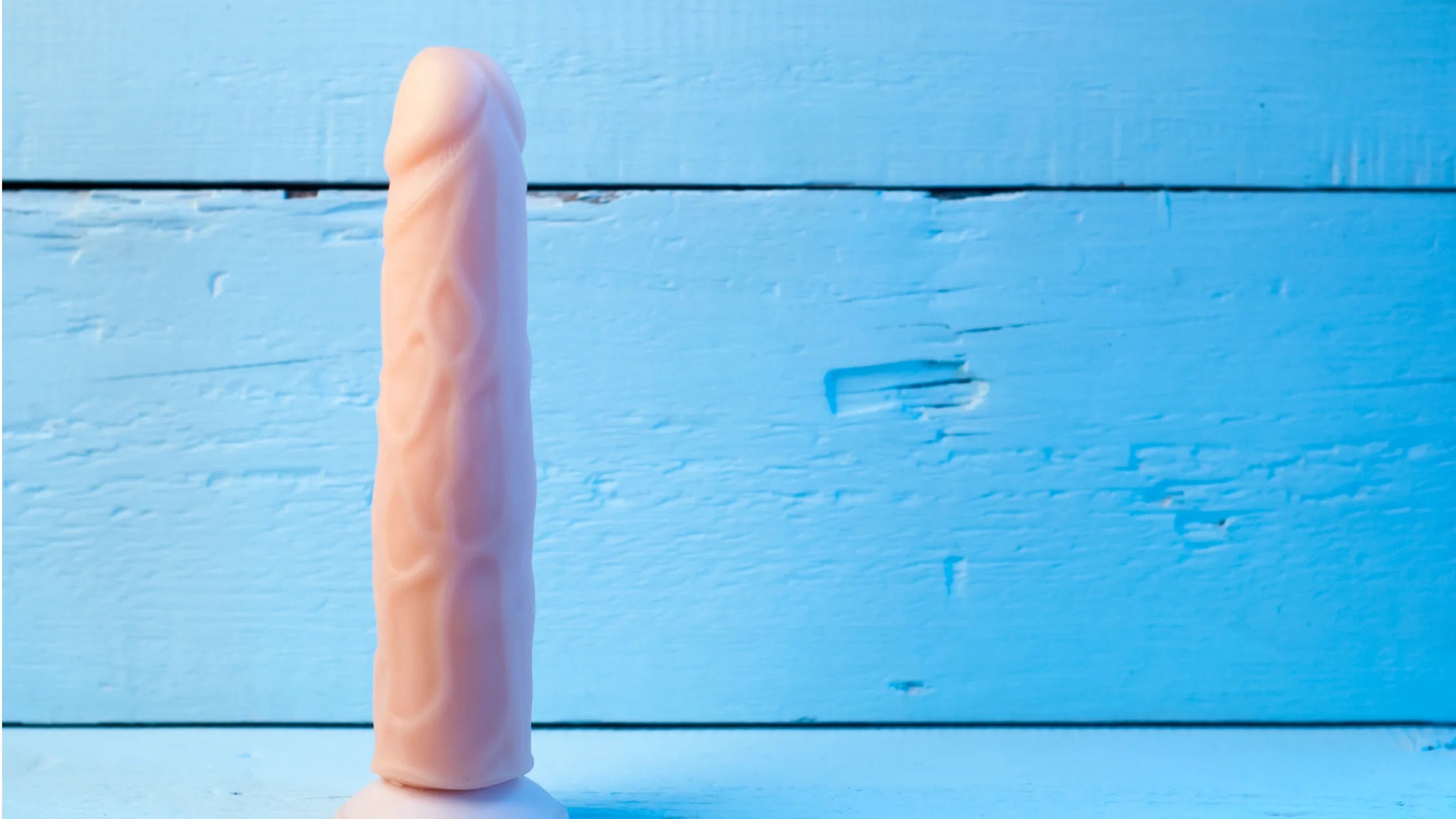 realistic vibrator flesh color with blue back drop numen wellness.